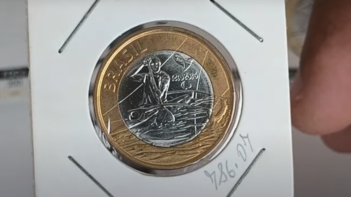 Moeda de 1 real de Paracanoagem de 2016, exibindo erro de cunhagem, com o atleta no centro.