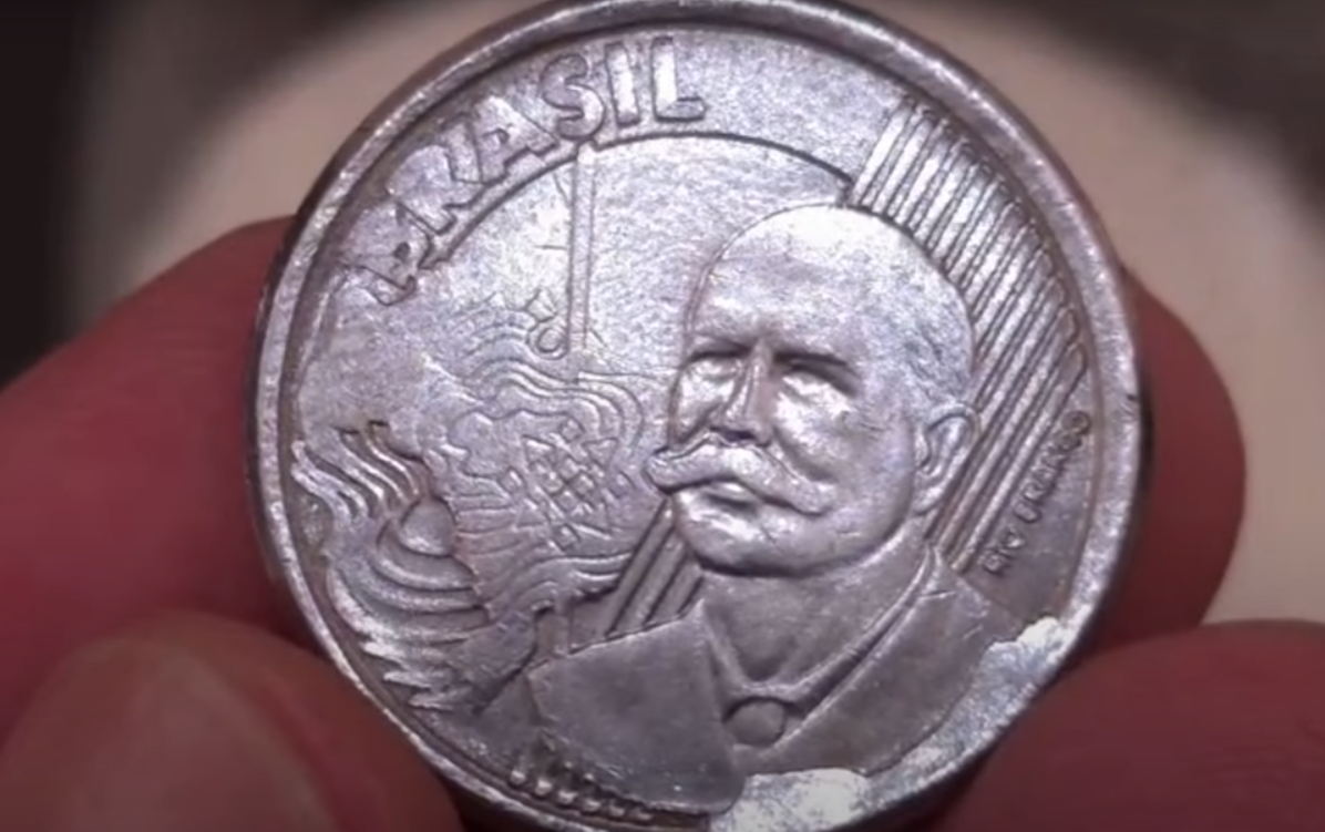 Moeda de 50 centavos com sobra de metal (erro de cunhagem) Moeda de 50 centavos com erro de cunhagem, mostrando sobra de metal na borda.