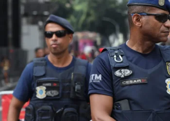 Dois membros da Guarda Municipal de Rio de Janeiro em patrulhamento, com uniformes de segurança e fardamento tático, durante ação na cidade.