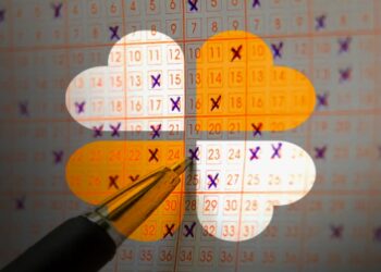 Cartela de loteria com números marcados e uma caneta, ilustrando a escolha dos números para um sorteio.