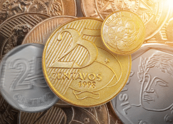 Moedas de 25 centavos e outras denominações brasileiras em destaque com efeito de brilho