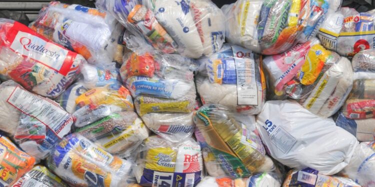 Cestas básicas empilhadas com diversos alimentos.