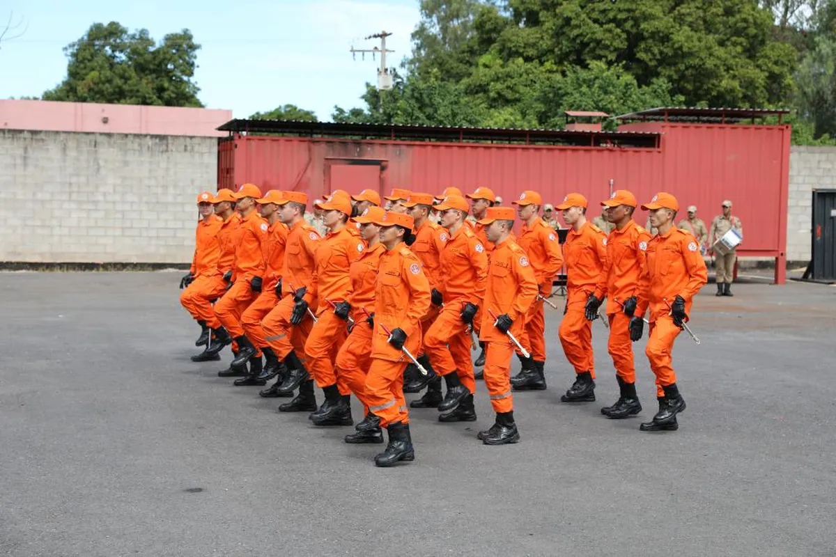 Bombeiros em treinamento, marchando em formação durante exercício.
