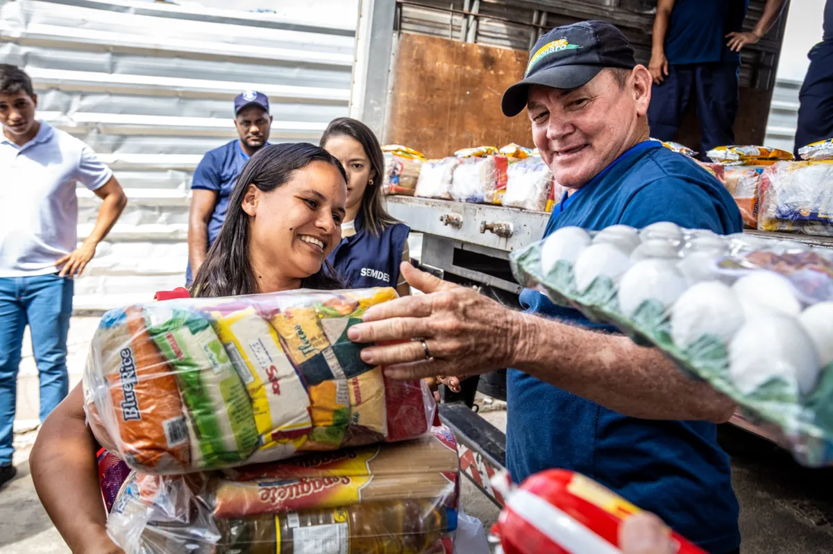 Entrega de cesta básica para moradora em ação social comunitária