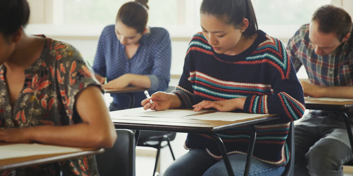 Enem 2025 Estudantes participando de uma prova no Enem 2025, focando no momento de escrita em sala de aula.