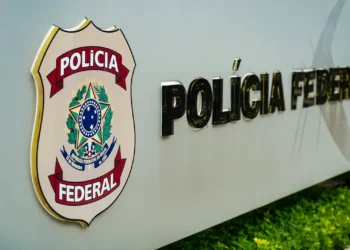 Brasão da Polícia Federal do Brasil ao lado da inscrição em fachada institucional Brasão da Polícia Federal do Brasil ao lado da inscrição em fachada institucional.