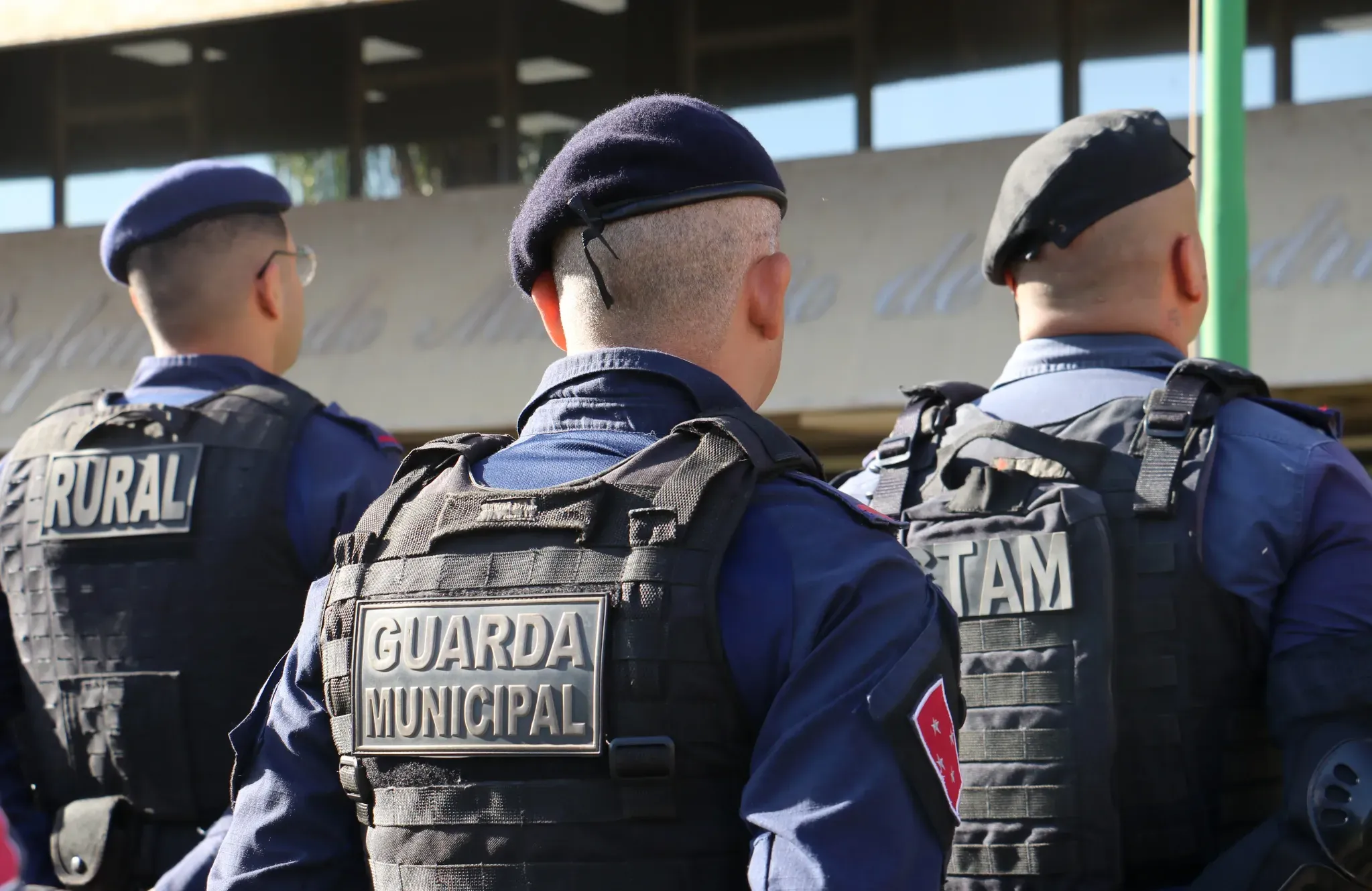 Guardas Municipais em ação com uniformes e equipamentos de proteção, incluindo a divisão Rural e TAM.