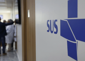 Logo do SUS em hospital, com profissionais e pacientes ao fundo, simbolizando nova parceria com a rede privada.