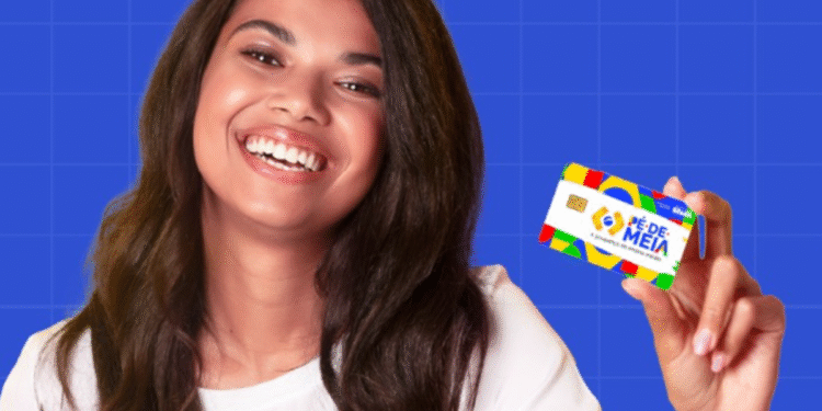 Jovem sorrindo e segurando o cartão do programa 'Pé-de-Meia', representando a inclusão financeira dos estudantes.