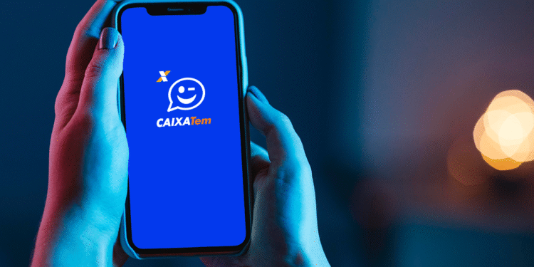 Pessoa segura celular com aplicativo Caixa Tem aberto na tela