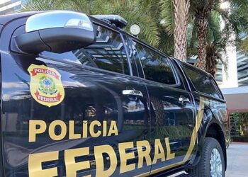 Veículo da Polícia Federal com emblema visível, estacionado em um ambiente urbano.