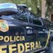 Veículo da Polícia Federal com emblema visível, estacionado em um ambiente urbano.
