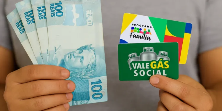 Pessoa segura notas de 100 reais e cartões do Bolsa Família e Vale Gás Social.