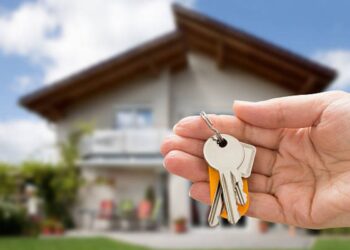 Mãos segurando chave e miniatura de casa simbolizando inscrição online para programa habitacional