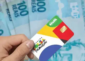 Cartão do Bolsa Família em destaque, com cédulas de dinheiro ao fundo, representando as datas de pagamento do benefício em agosto de 2026.