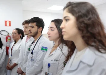 Estudantes de medicina uniformizados em ambiente hospitalar.