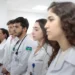 Estudantes de medicina uniformizados em ambiente hospitalar.