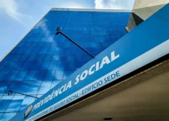 Imagem da sede do INSS, com a fachada visível, em azul e branco, anunciando informações sobre os pagamentos de agosto.