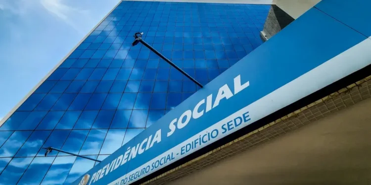 Imagem da sede do INSS, com a fachada visível, em azul e branco, anunciando informações sobre os pagamentos de agosto.