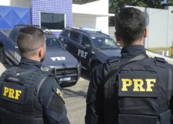 Policiais da PRF em frente a viaturas durante operação em unidade da corporação.