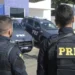 Policiais da PRF em frente a viaturas durante operação em unidade da corporação.