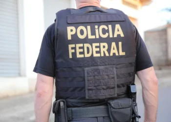Agente da Polícia Federal em operação com colete tático.