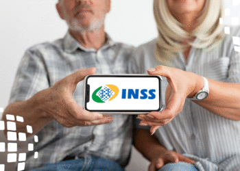 Imagem de casal idoso segurando celular com logo do INSS na tela