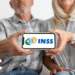 Imagem de casal idoso segurando celular com logo do INSS na tela