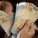 Dinheiro em notas de 50 reais, representando o valor do pagamento especial de R$ 2.227.