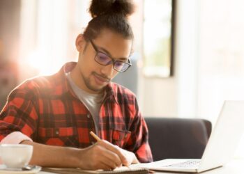 ovem com óculos estudando em um ambiente tranquilo, simbolizando a retomada dos estudos para concursos com uma nova perspectiva.