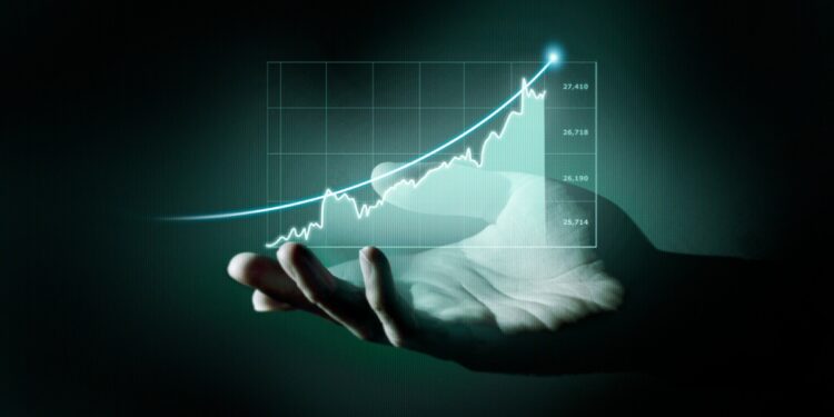 Mão segurando gráfico holográfico ascendente com valores financeiros simbolizando crescimento de investimentos