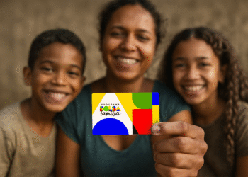 Família sorrindo, mãe segura o cartão do Bolsa Família com o novo design colorido.