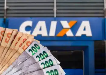 Cédulas de 200 e 50 reais em frente ao logo da Caixa Econômica Federal.