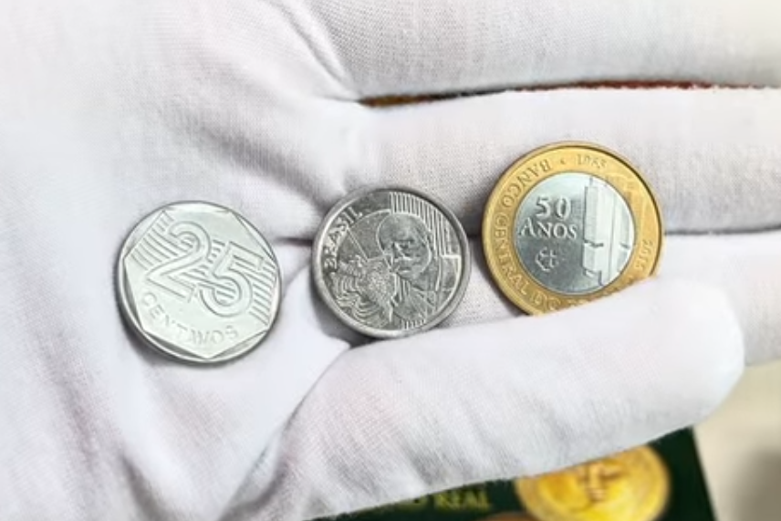 Moedas raras: 3 exemplares que podem valer uma fortuna no mercado numismático Três moedas brasileiras raras sendo exibidas por colecionador com luva branca