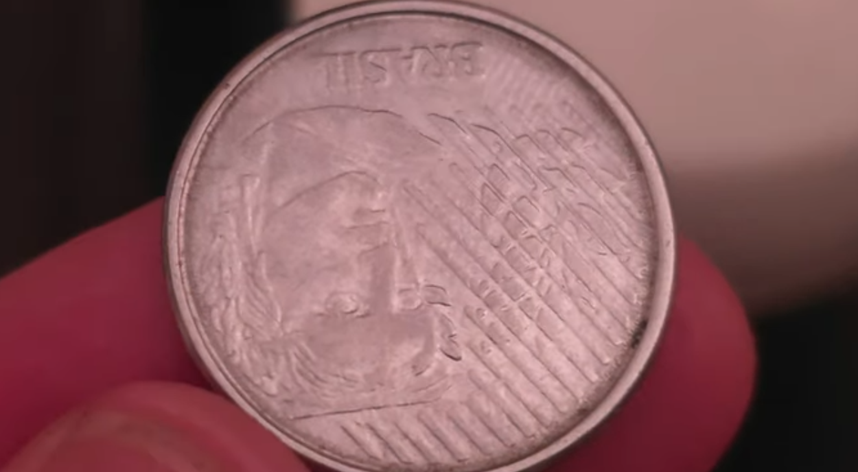 Erro raro em moeda de 10 centavos chama atenção de colecionadores Moeda de 10 centavos de 1994 com erro de reverso invertido sendo exibida de perto