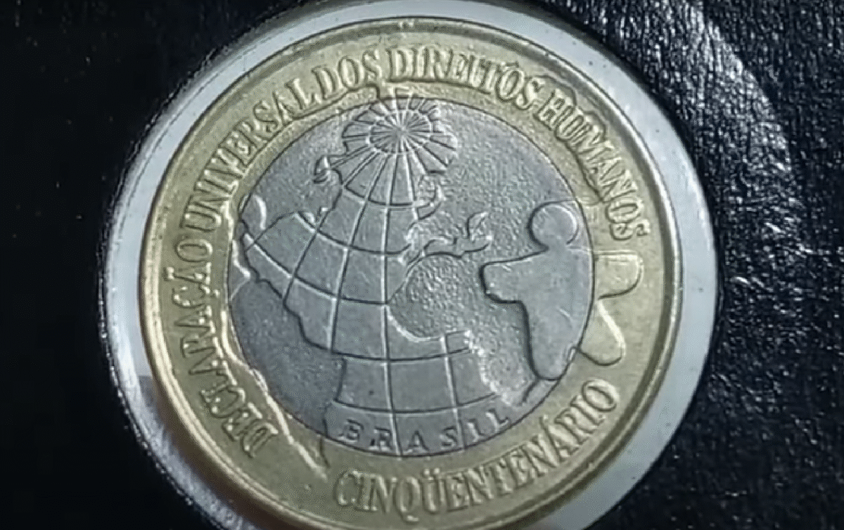 Moeda Comemorativa dos Direitos Humanos Moeda de 1 real comemorativa dos direitos humanos, com a inscrição 'Declaração Universal dos Direitos Humanos'.