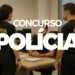 Três policiais federais interagindo em uma sala de trabalho com computadores, relacionados ao concurso da Polícia Federal.