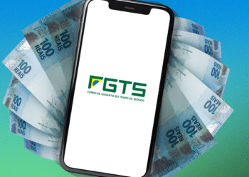 Aplicativo do FGTS exibido em celular com notas de 100 reais ao fundo