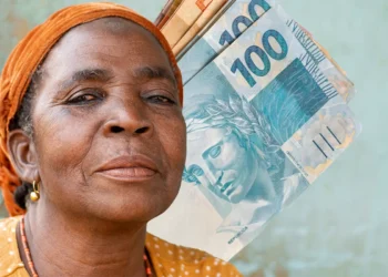 Aposentada refletindo sobre sua situação financeira com cédulas de 100 reais ao fundo.