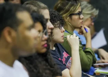Grupo de estudantes concentrados em sala de aula durante atividade