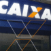 Fachada iluminada da agência Caixa Econômica Federal com logo em destaque