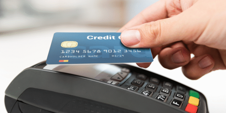 Pessoa efetuando pagamento com cartão de crédito em máquina de cartão moderna.
