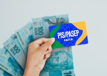 Cartão PIS/Pasep com notas de 100 reais ao fundo