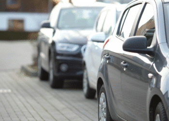 Automóveis estacionados lado a lado em uma calçada urbana pavimentada