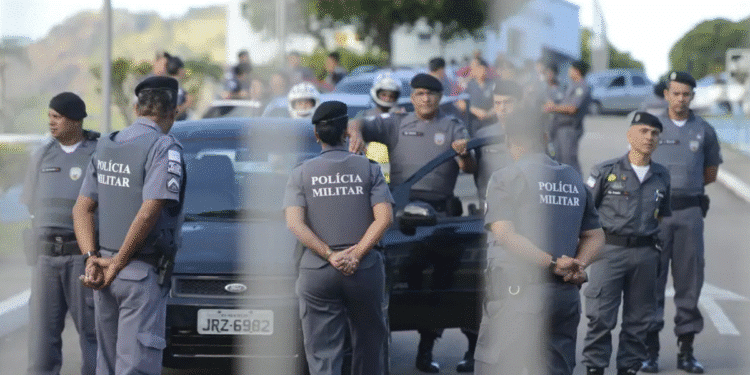 Policiais militares em operação cercando um carro preto em uma rua no Brasil.