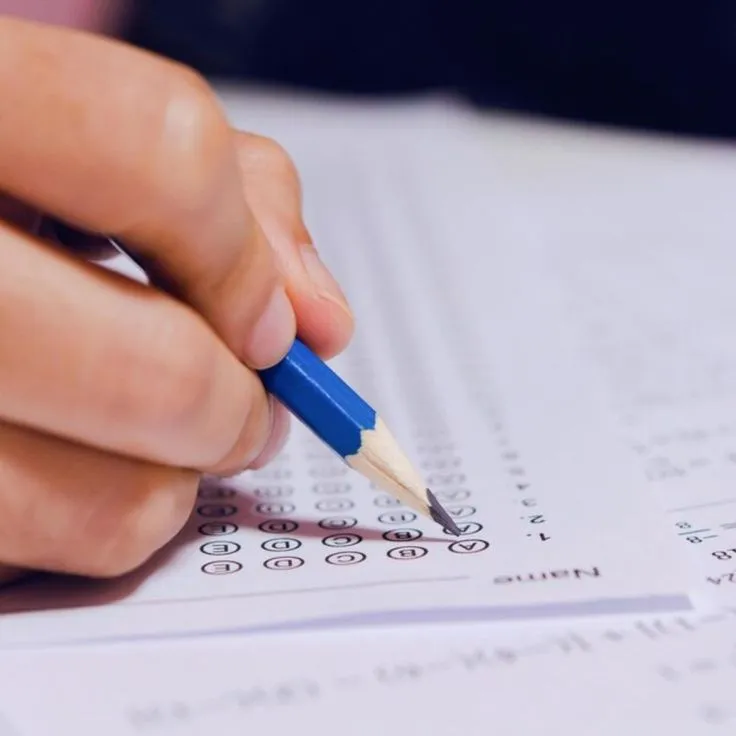 Pessoa preenchendo uma prova, representando a preparação para o concurso Aeronáutica, com foco no processo seletivo e prorrogação das inscrições