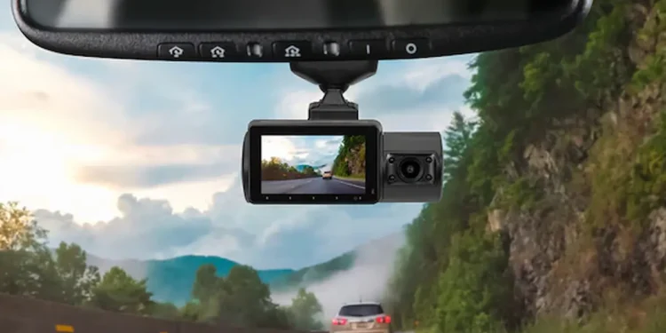 Câmera veicular registrando estrada e carro à frente, com paisagem montanhosa ao fundo.