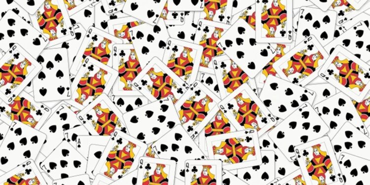 Desafio visual com diversas cartas de baralho, principalmente damas e ases, espalhadas aleatoriamente.