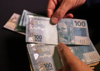 Notas de cem reais representando aumento no salário mínimo regional