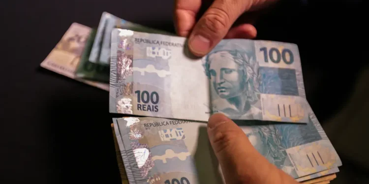 Notas de cem reais representando aumento no salário mínimo regional